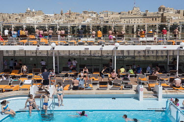 Passengers look out over Valetta from a deck onboard the MSC Lirica a cruise ship, belonging to the Mediterranean Shipping Company, as it heads towards the cruise terminal in the Grand Harbour.