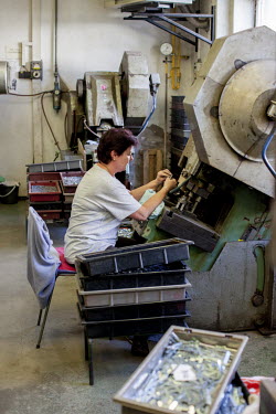 A worker at the 'Merkur' (Mercury) construction toy factory machines parts used in the company's toy sets.