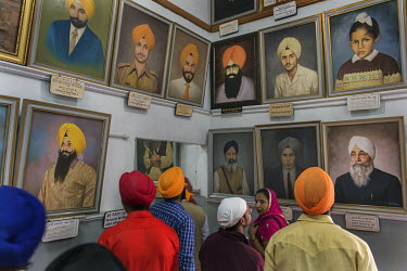 People studying the portraits of important Sikh personalities in the museum at Amritsar's Golden Temple.