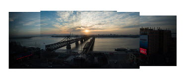 The Chinaâ�"North Korea Friendship Bridge and The Yalu River Broken Bridge (R) seen from a hotel window during the sunset in winter. The bridges connect Dandong in China with Sinuiju.