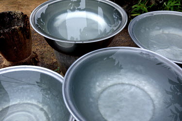 Metal basins filled with water at a Georgekro cocoa farmers' settlement.