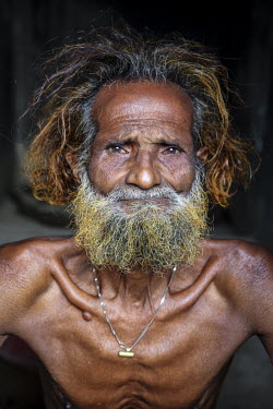 A bare chested elderly man.