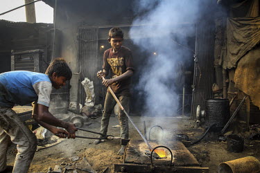 Child labourers, with no safety equipment, smelting metal for casting ship's propellors..