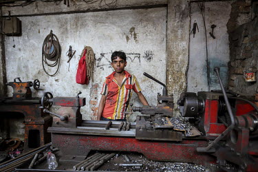 A boy working in a factory making door handles and locks.