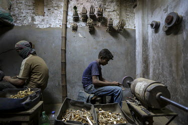 A boy working in a factory making door handles and locks.