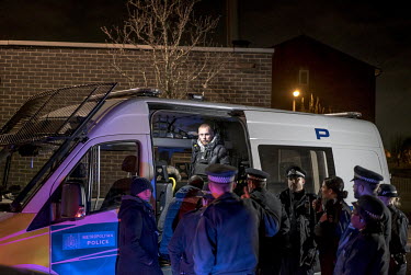 Members of a police Violent Crime Task Force gather around a van during an operation against a gang operating in a park in north London.