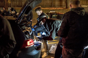 Members of a police Violent Crime Task Force search a car for drugs during an operation against gangs in north London.