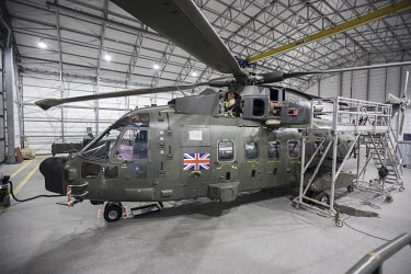 A British Merlin helicopter in a heated hangar in the Arctic during Joint Helicopter Command training.~~845 Naval Air Squadron is a squadron of the Royal Navy's Fleet Air Arm. Part of the Commando Hel...