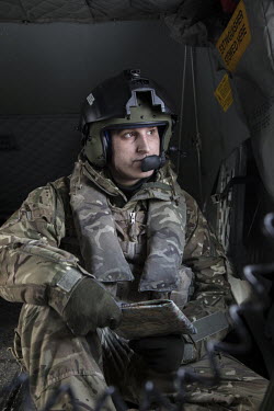 An air crew member looks out the window of a British Merlin helicopter during exercise Clockwork in the Arctic.  845 Naval Air Squadron is a squadron of the Royal Navy's Fleet Air Arm. Part of the C...