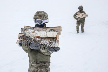 Soldiers carry firewood dropped off by helicopter at the newly built Vouma cabin in the Dividalen National Park, a part of the Norwegian Trekking Association network. As a goodwill gesture, and part o...