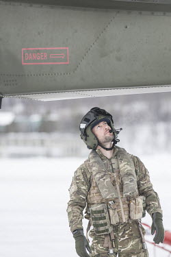 A pilot inspects his helicopter prior to a mission during exercise Clockwork in the Arctic.  845 Naval Air Squadron is a squadron of the Royal Navy's Fleet Air Arm. Part of the Commando Helicopter F...