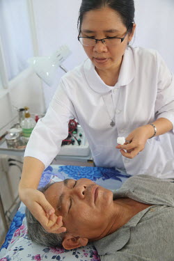 An acupuncturist treats a patient at a clinic for traditional Chinese medicine.