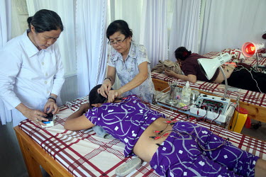 An acupuncturist treats a patient at a clinic for traditional Chinese medicine.
