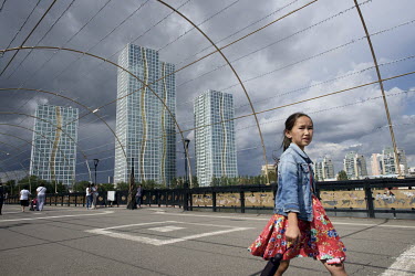 A child walks past modernist highrise buildings near the Ishim River.