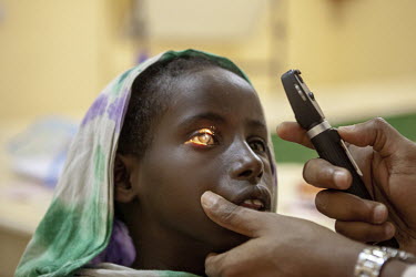 Dr. Abdirisak Ahmed Dalmar observes a young patient's eyes in Galkayo hospital.