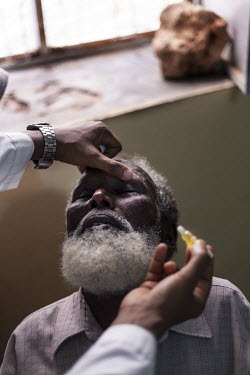 Dr. Abdirisak Ahmed Dalmar applies eye drops prior to an examination of a patient in Galkayo hospital.