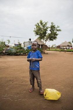 A young boy plays with a plastic bag attached to string.According to the UNHCR 60% of the refugees fleeing South Sudan are children. As in all Uganda's refugee settlements, the number of children amon...