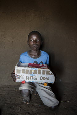 Isaac Lemi (13), a refugee boy living in the Bidibidi camp, holds a toy bus he made out of a cardboard box that formerly contained food aid from the World Food Program. According to the UNHCR 60% of t...