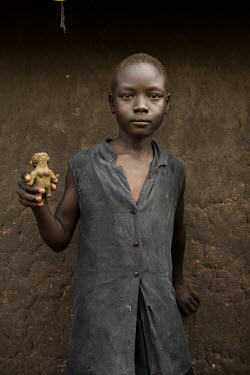 Susan James (10), a child from Ariwa, a village intergrated with zone 5 of Bidibidi refugee camp, holds her homemade clay doll.