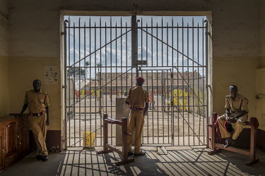 Guards at Luzira Prison at the gate into a courtyard where there is a football league played among inmate sides.
