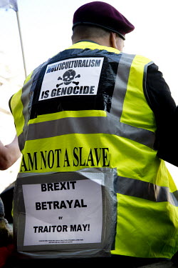 A man wearing a yellow vest with a sign taped on his back that reads: 'multiculturism is genocide', as 'Leave' (the EU) supporters gather for a 'Make Brexit Happen' rally in Whitehall, aggrieved that...