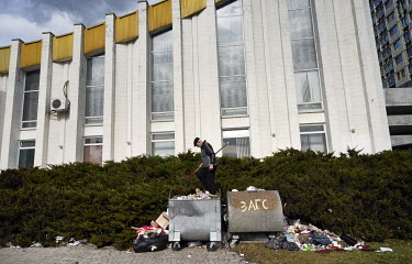 A man stamps down rubbish in a container in front of the Civil Registry Office Central Wedding.