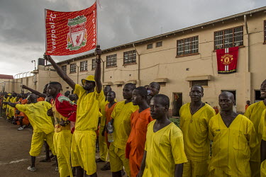 Fans watch a football match played at Luzira Prison between teams composed of inmates, Liverpool in black versus Manchester United in Red. A league, made up of several sides named after UK Premier Lea...
