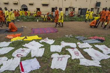 Prisoners in a courtyard at Luzira Prison where there is a football league played among inmate sides. The jerseys of one of the prison's football teams are drying in the courtyard.