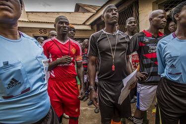 Officials and players come out for a football match played at Luzira Prison between teams composed of inmates, Liverpool in black versus Manchester United in Red. A league, made up of several sides na...