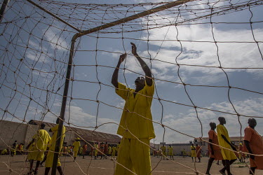 Inmates set up the nets for a football match played at Luzira Prison between teams composed of inmates, Liverpool in black versus Manchester United in Red. A league, made up of several sides named aft...