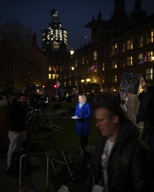 A television journalist talks to camera on College Green as the media report on a tense Parliamentary session as MPs debated the Prime Minister's Brexit deal in the nearby House of Commons. This follo...