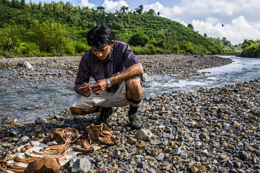 Sitting by a stream, vet Dr. Myo Min Aung looks at the remaining bones of deceased baby elephant Mi Chaw which he excavated in order to keep a memory of her at his home, at Thayatsan elephants camp. A...