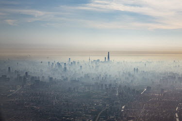 An aerial view of Shanghai showing skyscrapers silhouetted against the morning smog.