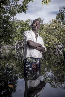 Richard Divine (57) in a mangrove forest he is helping to expand near Tampolove village. Alongside the environmental benefits of planting mangroves, the villagers are due to start trading in carbon cr...