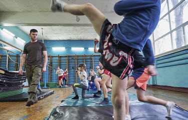 Children warming up during a Thai boxing lesson. Oleksiy Yukov from the Black Tulip humanitarian organisation, which searches for the bodies of missing people, has trained people in Thai boxing for se...