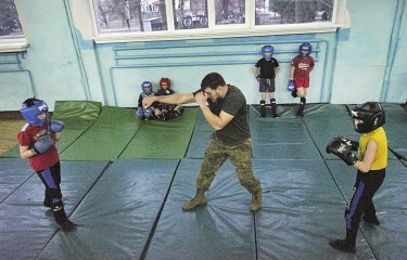Oleksiy Yukov training children during a Thai boxing lesson. Oleksiy Yukov is from the Black Tulip humanitarian organisation, which searches for the bodies of missing people, has trained people in Tha...