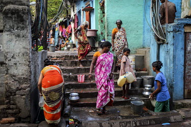 Women and children collecting water in various containers.