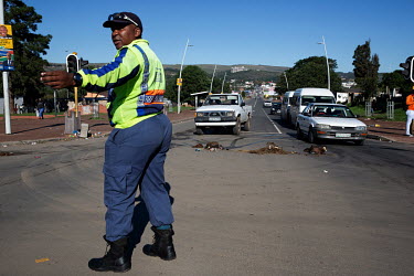 A policeman directs traffic around piles of faeces that had been dumped in the main road ahead of a visit by President Cyril Ramaphosa for a Freedom Day event. The municipality is notorious for its sa...