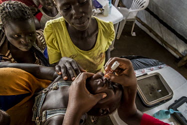 A South Sudanese refugee child is given an oral vaccination from a medic at the Imvepi reception centre.