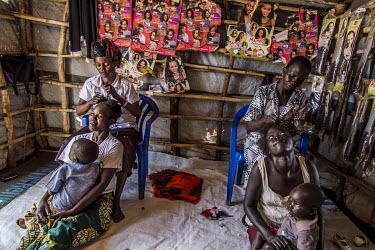 South Sudanese refugee Rose Jacqueline (27) (left) in her hairdressing salon in Bidibidi camp, zone #2. She paid 65,000 Ugandan Shillings to a local for the 3x3 metre plot. It was named the 'NSM femal...