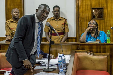 Dr Stella Nyanzi listens from the dock at the Buganda Road Chief Magistrate's court on 9 May 2019. One of her lawyers, Derrick Bazekuketta, talks with the magistrate during the cross examination of de...