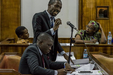Dr Stella Nyanzi listens from the dock at the Buganda Road Chief Magistrate's court on 13 May 2019. One of her lawyers, Isaac Ssemakadde, speaks during the cross examination of detective Bill Ndyamuha...