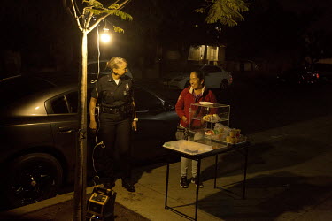 Ruby Flores, Police Captain at the Hollenbeck Community Police Station in Boyle Heights, speaks with a street vendor after visiting the Resurection Church in Boyle Heights. She asked her officers to v...