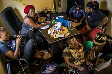 In the office of an LGBTI organisation, the team behind the 'Pad4GirlsUg' campaign, talk with activist Stella Nyanzi (using laptop, about a way forward in their campaign to educate young people about...