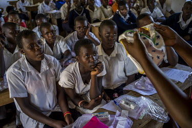 Secondary school students listen to a presentation about sanitary pads and how to use them, during the first visit and launch of activist Dr Stella Nyanzi's campaign, 'Pads for Girls'.