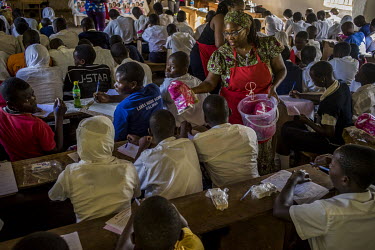 Dr Stella Nyanzi distributes sanitary pad kits to female secondary school students during a presentation about female reproductive health, a part of Nyanzi's 'Pads for Girls'campaign.