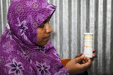 A medical worker performs a pregnancy test on Kohinur Begum at a small satellite clinic.