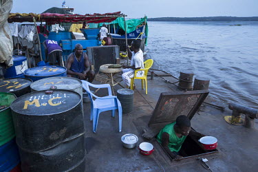 Passengers and crew go about their daily routine on the deck of a barge travelling up the Congo River towards Kisangani