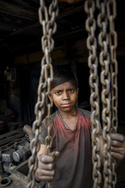 A child labourer in a workshop producing parts for the ship building industry.