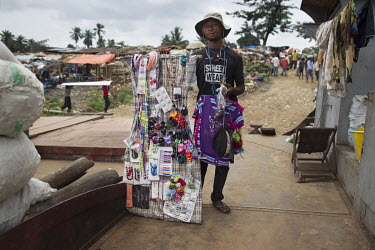 Kisangani marks the end of the navigable route of the Congo river. This city already looks to the east. The clothes and accessories being sold by this hawker come from Uganda, Tanzania and further afi...
